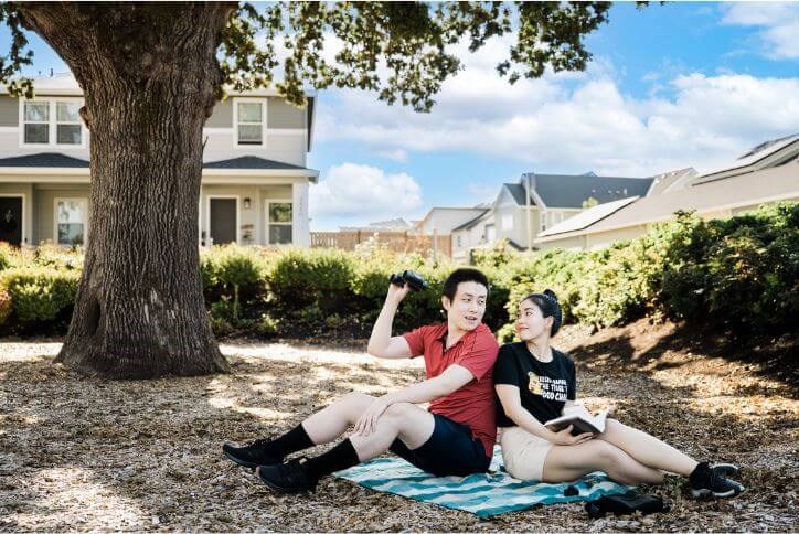 In Hillsboro’s Oak Grove Park, a millennial couple sits on a plaid blanket to enjoy bird watching with binoculars.