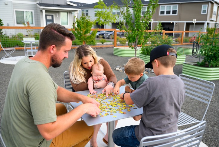 A family with three small children solves a puzzle in the Reed’s Crossing Community Garden.