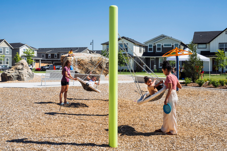 Two mothers push their kids on the swings in Reed’s Crossing Park.