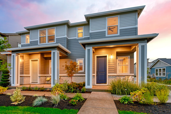 Paired homes by Richmond American at Reed’s Crossing are framed by a brilliant sunset.