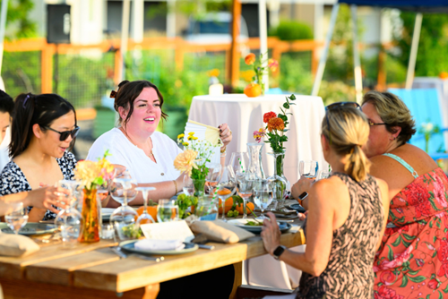 A group of women shares a meal in the Reed’s Crossing community garden.