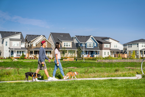 A couple and two dogs walk along a multimodal path at Reed’s Crossing in Hillsboro, Oregon.