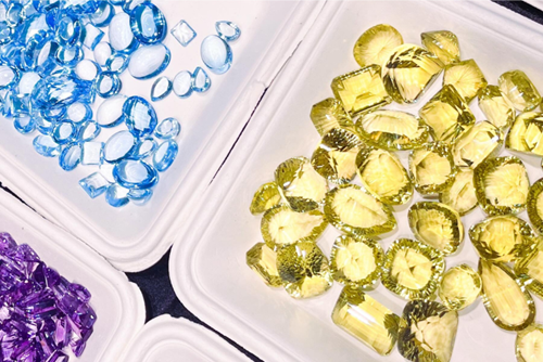 Yellow, blue, and purple gems are organized into piles at the Hillsboro Gem Faire.