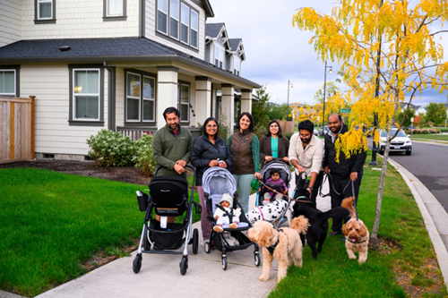 A group of adults, children, and dogs out for a walk near Tamarack Park in Reed’s Crossing.