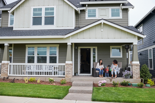 A family sits on a porch to chat in Hillsboro’s Reed’s Crossing neighborhood.