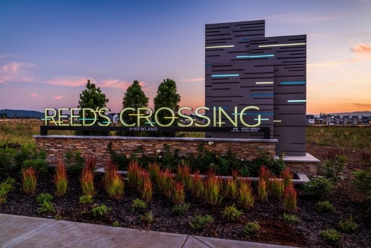 At sunset, the sky turns purple behind the Reed’s Crossing entry monument.