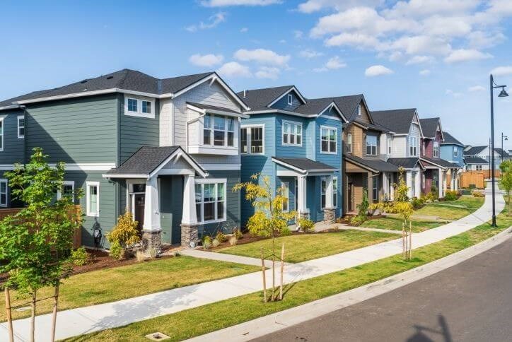 A colorful row of homes on a tree-lined street in Reed's Crossing in Hillsboro, Oregon.