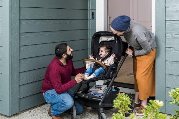 A couple takes their baby for a walk.