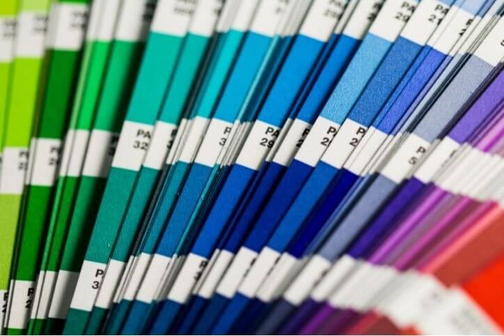 Alt text: A rainbow of Pantone color samples fanned out on display.