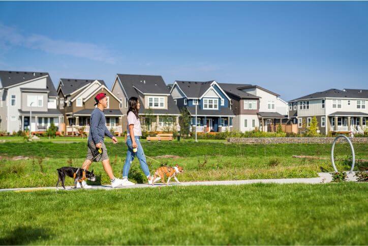A millennial couple walks two dogs at Reed’s Crossing.