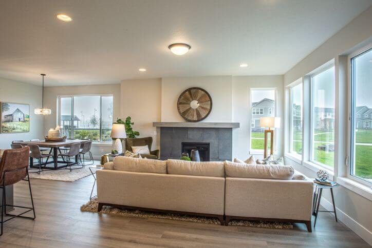 An open-concept living area from Stone Bridge Homes NW connects the living room, kitchen, and dining room in a light and airy layout.