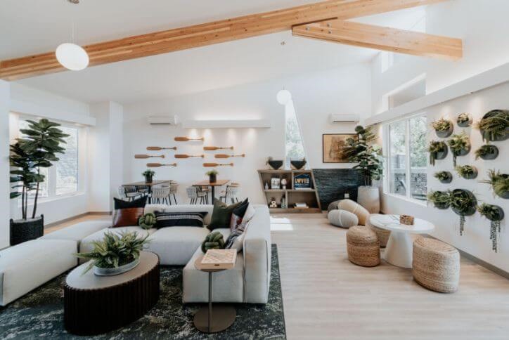 A Pacific Northwest-inspired living room featuring a plant wall and warm wooden beams.