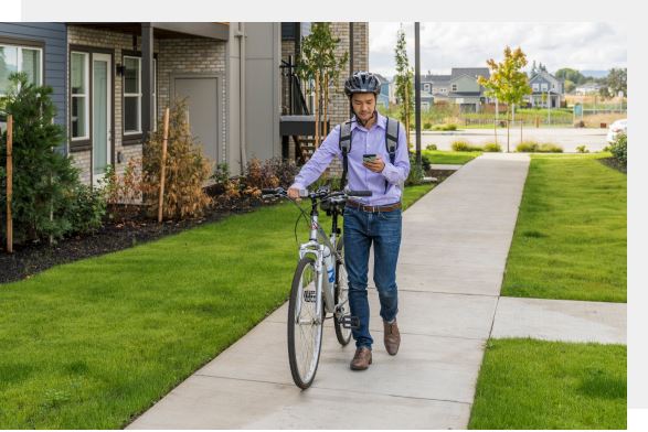 Resident of Reed's Crossing community in Hillsboro, OR walking with bike