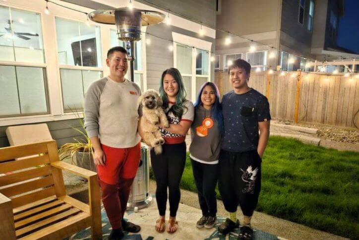 Family photo of Reed’s Crossing residents posing in a backyard decorated with string lights.