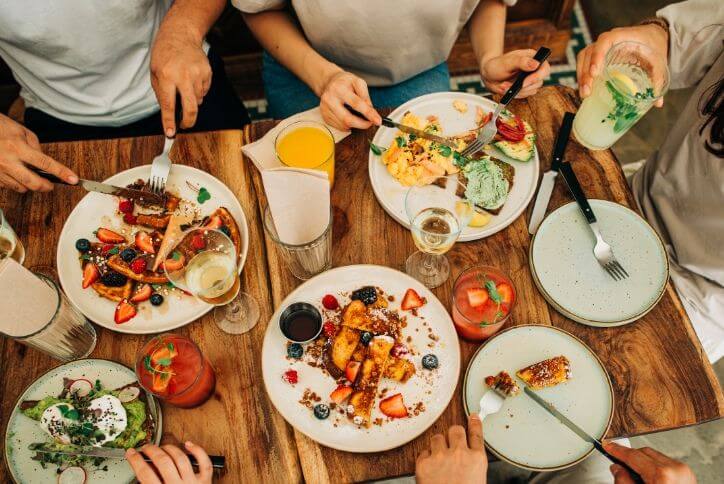 Above-the-table view of a group of friends eating brunch in a restaurant.