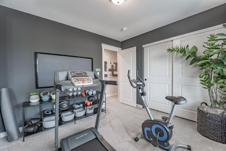 An exercise bike, treadmill, weights, and other equipment fill a home gym at Reed’s Crossing.