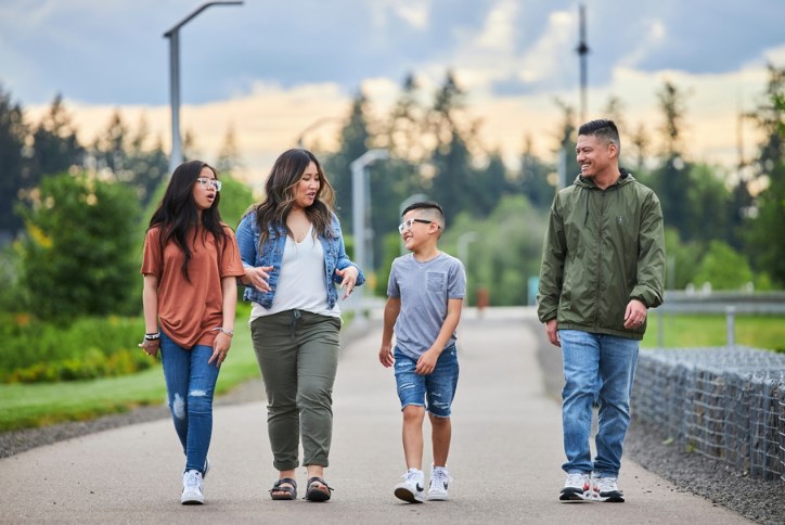 A family walks along the Reed’s Crossing Greenway.