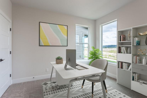 A tidy home office with a computer desk and bookshelves is a great use of a flex space.