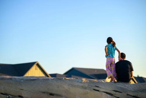 A father and daughter enjoy a quiet moment at the boulder garden in Reed’s Crossing Park.
