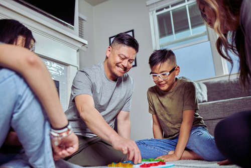 A family enjoys game night in a home in Reed’s Crossing.