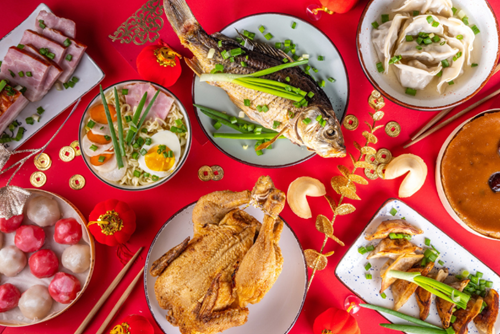 A red table spread with dishes to celebrate Lunar New Year.