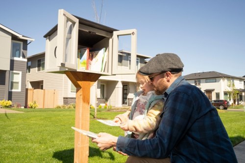 A father and daughter select books from a Little Free Library in Hillsboro’s Reed’s Crossing community.