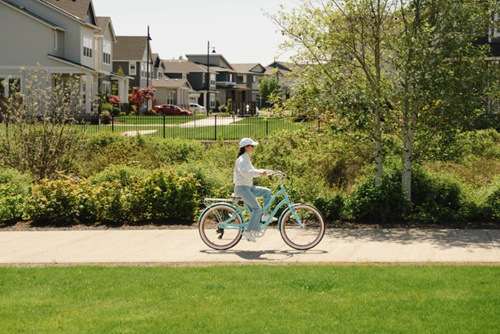 A woman rides a bicycle along the Reed’s Crossing Greenway.