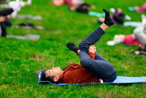 A man does a yoga pose during a community yoga class in Reed’s Crossing Park.