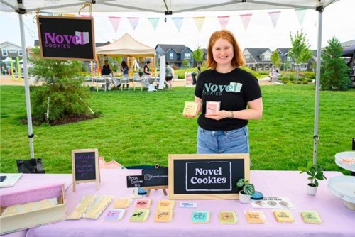 The owner of Novel Cookies poses in her booth at Hillsboro Farmers’ Market in Reed’s Crossing.