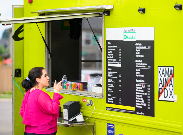 Woman selects from a menu at a food truck.
