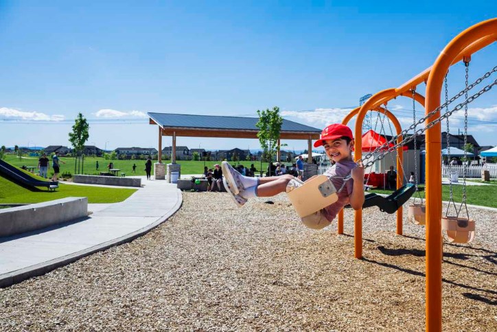 A child swings on a swing set in Reed’s Crossing Park.