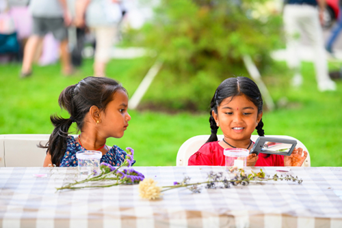 Two children learn about plants with the Hillsboro Farmers’ Market kids club.