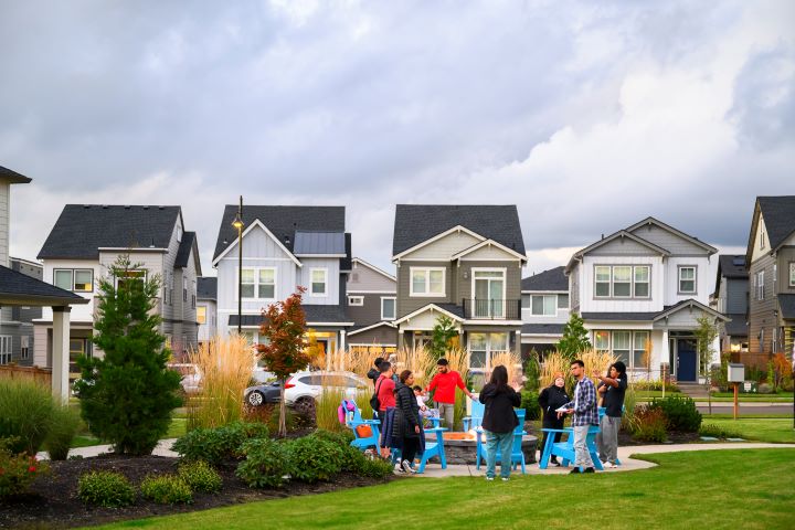 Residents gather around a firepit in a community common area.