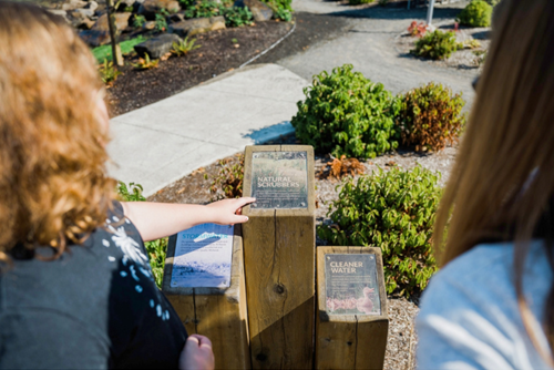 Children point to nature facts on display in the Reed’s Crossing Nature Education Area.