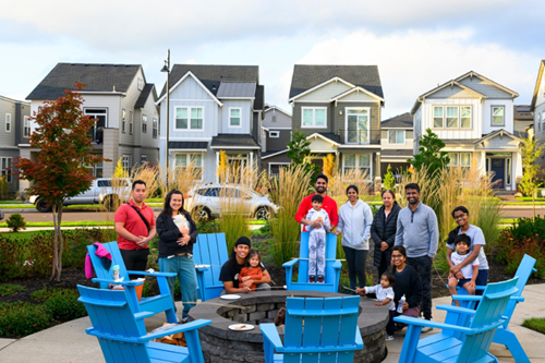 A group of Reed’s Crossing residents pose in front of a fire pit during a community event.