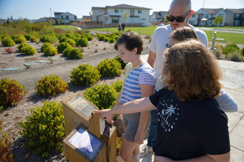 A family with two teenage daughters reads the educational plaques in the Nature Education Area at Reed’s Crossing.